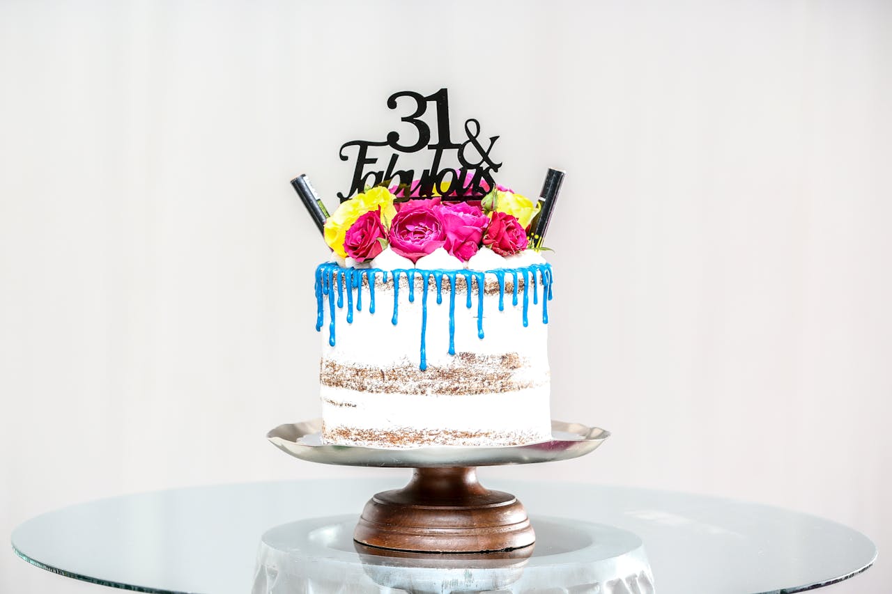 A stylish birthday cake with flowers and blue icing perfect for celebrations.